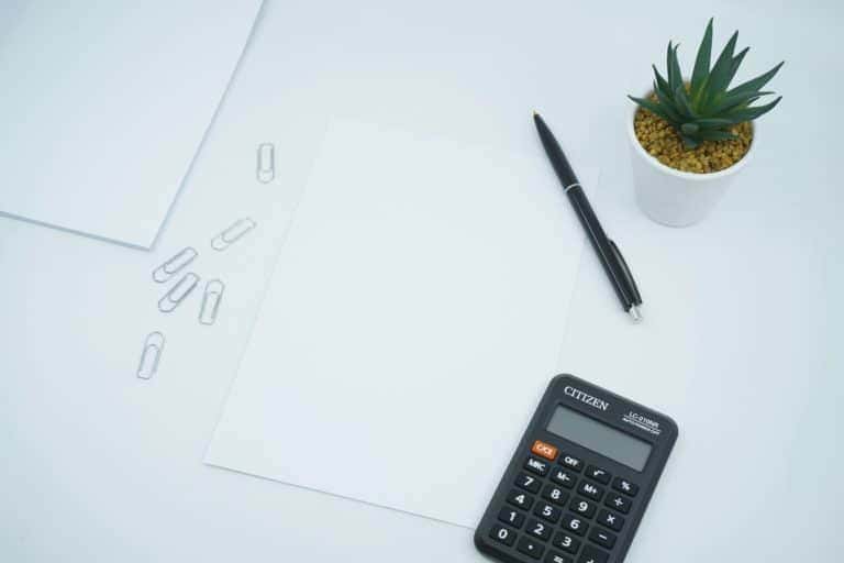 Image of a desk table with a calculator and pen Image of a desk table with a calculator and pen