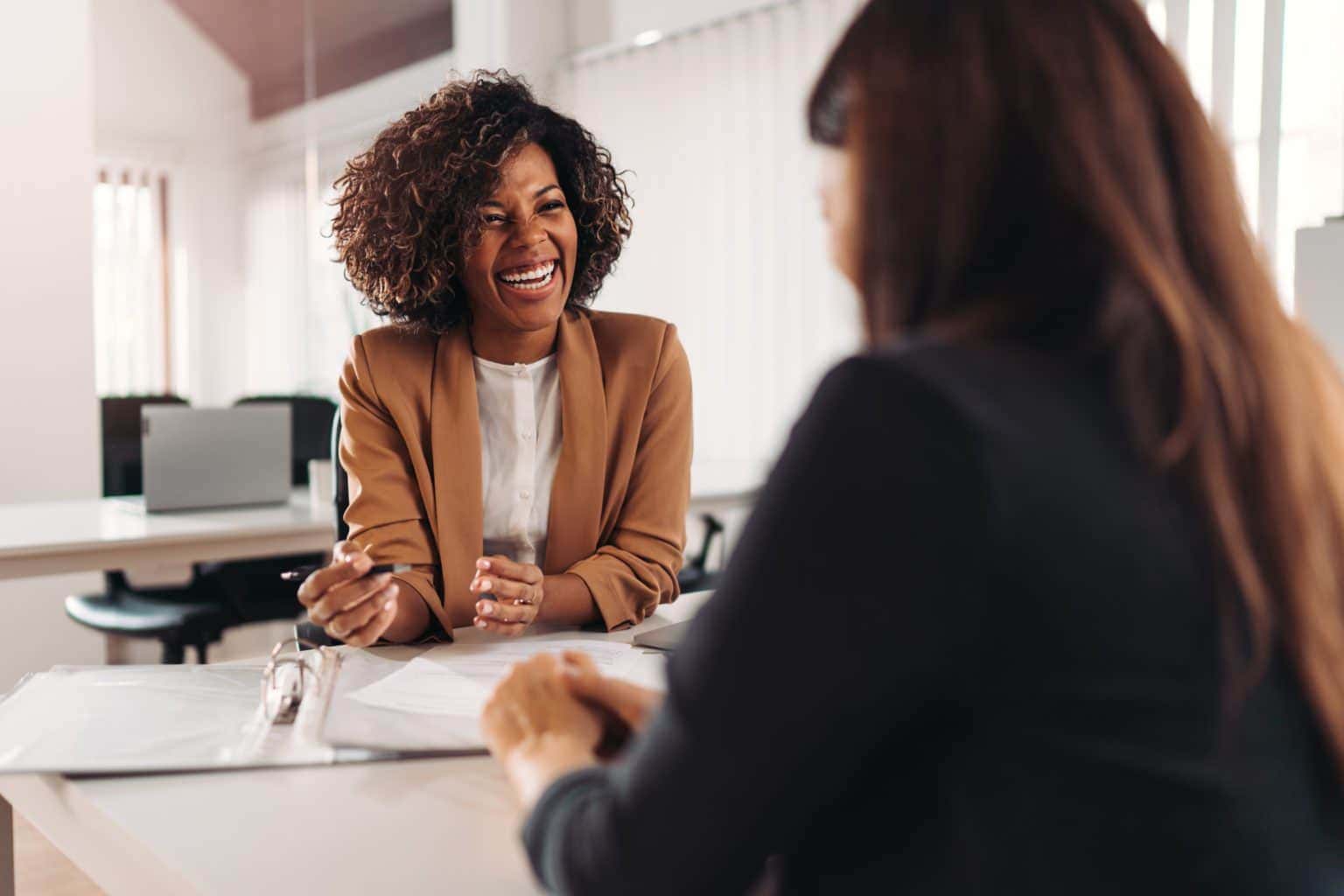 Image of two people talking to each other over a desk Image of two people talking to each other over a desk